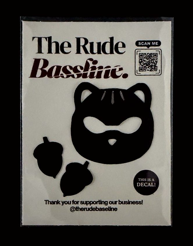 A black cat decal with two acorns on a Rude Bassline backing card in a clear sleeve